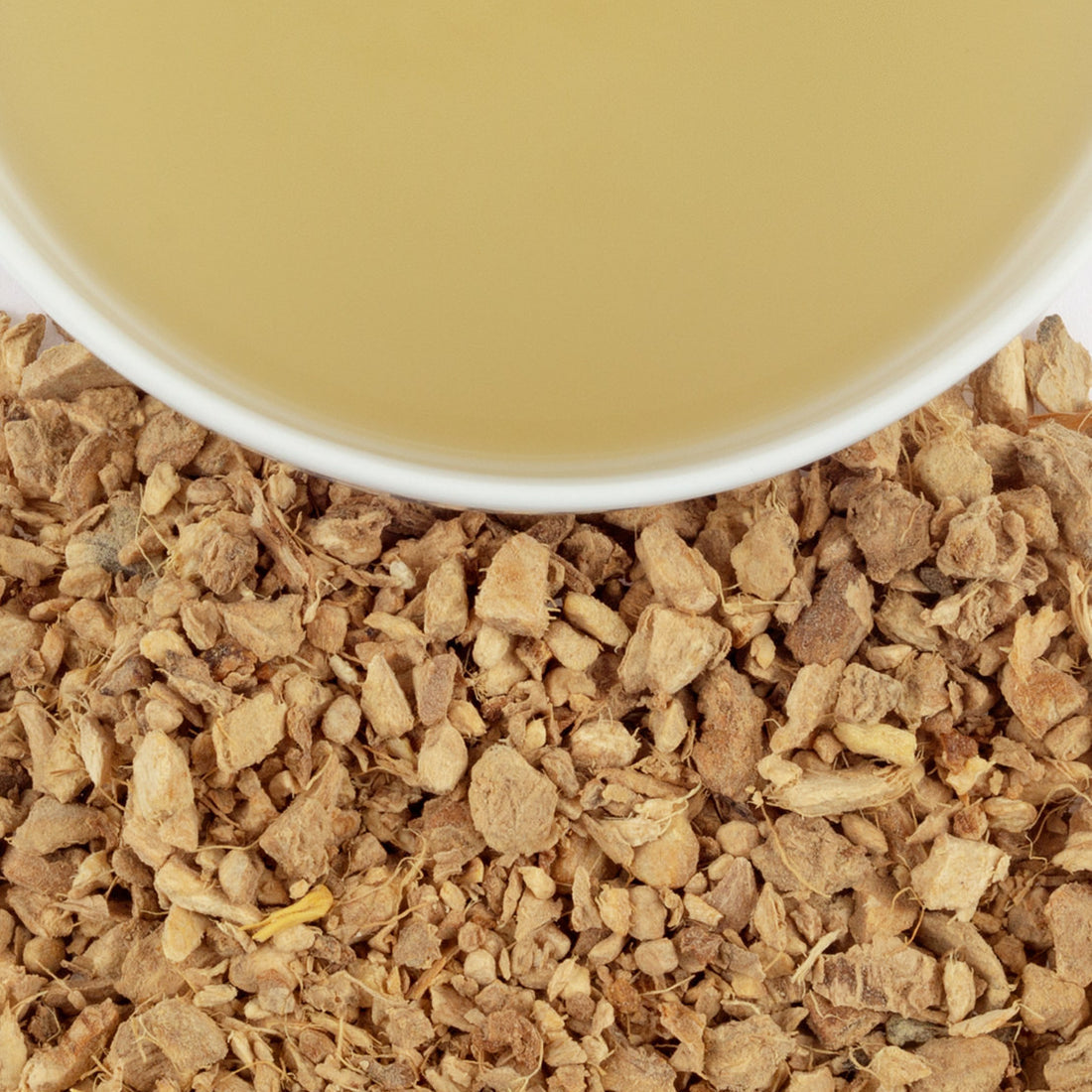 Close up of Harney & Sons loose leaf Ginger Lemon tea and cup of steeped tea