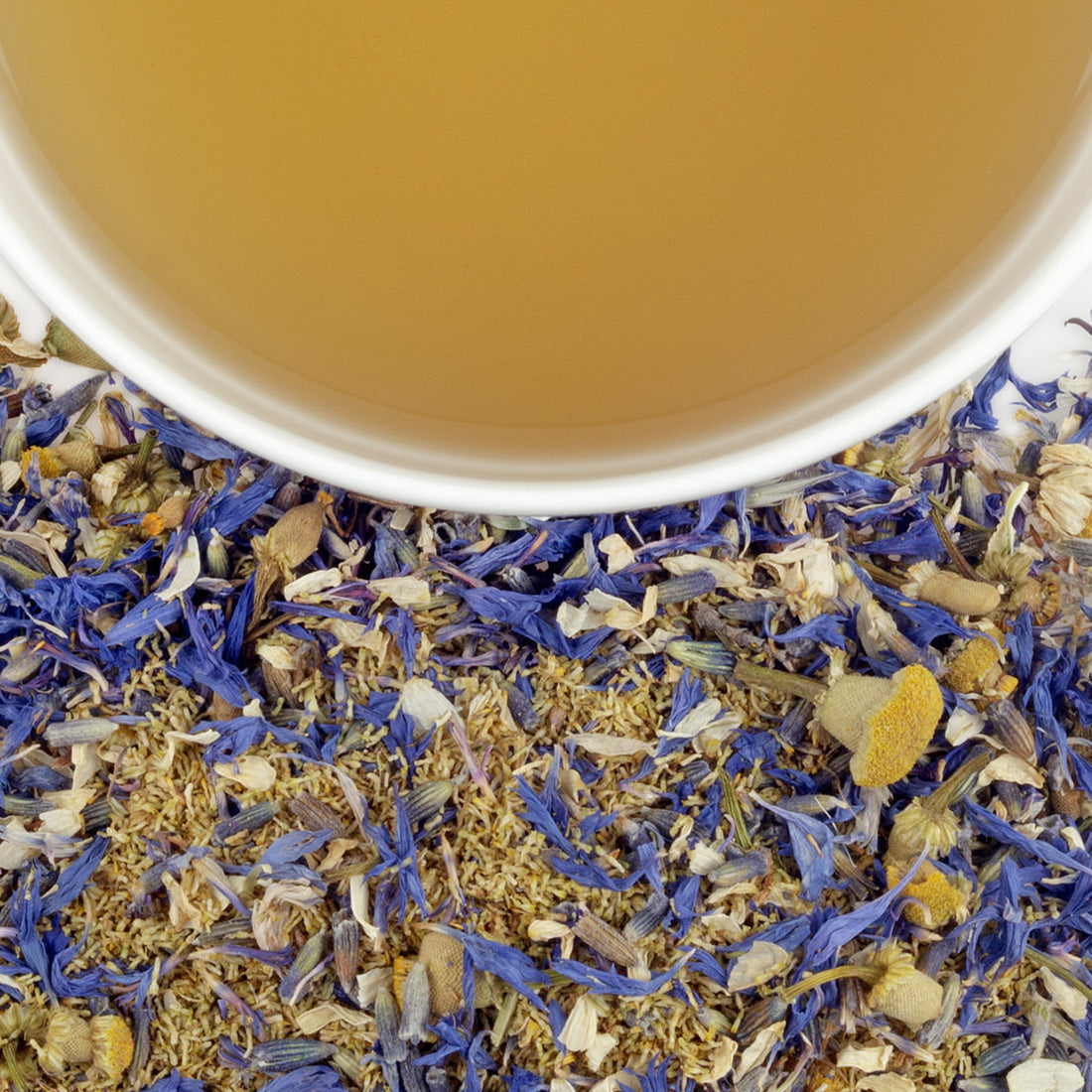 Close up of loose leaf tea made from dried chamomile, lavender, and cornflowers with a up of herbal tea