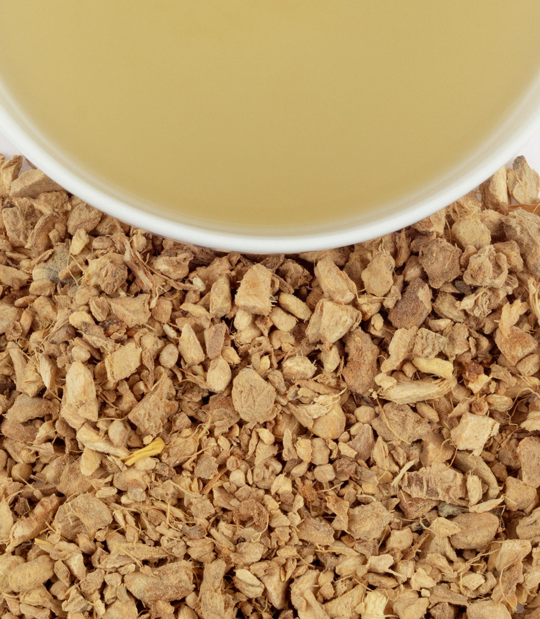 Close up of Harney & Sons loose leaf Ginger Lemon tea and cup of steeped tea