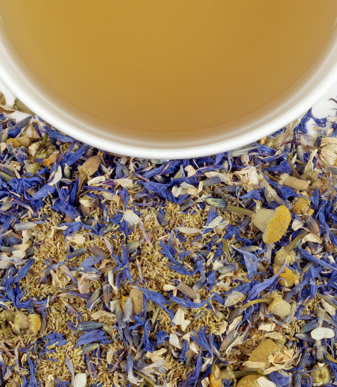 Close up of loose leaf tea made from dried chamomile, lavender, and cornflowers with a up of herbal tea  